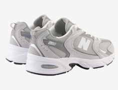 the new balance 997 sneaker in grey and white is shown from the side