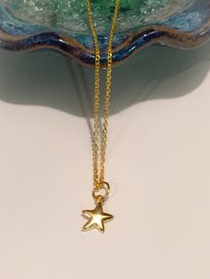 A delicate mini gold star necklace that's perfect for layering. The little star charm is made of 24k gold over sterling silver. This necklace looks great with any outfit whether it be at the office or a night out. Very feminine and dainty. The perfect everyday piece of jewelry for your girlfriend, mom, sister, wife or just something everyday pretty for yourself! This cute star necklace comes packaged in a beautiful gift box ready for gift giving. Each necklace is meticulously hand made in our st Dainty Yellow Gold Star Charm Necklace, Delicate Yellow Gold Charm Necklace With Star Charm, Delicate Yellow Gold Star Charm Necklace, Dainty Star Charm Necklaces, Dainty Star Of David Charm Necklace With Delicate Chain, Dainty Star-shaped Necklace With Starfish Charm, Dainty Star Charm Necklace, Dainty Gold Necklaces With Star Charm, Delicate Star Charm Necklace For Everyday