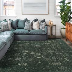 a living room with a large green rug on the floor next to a blue couch