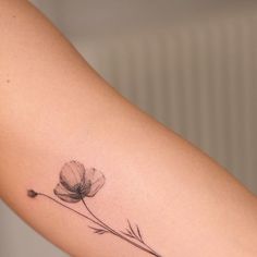 a single flower tattoo on the left arm and right arm, is shown in black ink