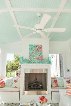 a living room filled with furniture and a fire place under a white ceiling mounted fan