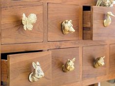 a wooden dresser with brass drawer pulls on it's sides and gold animal head knobs