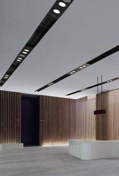 an empty room with wooden slats on the walls and lights hanging from the ceiling