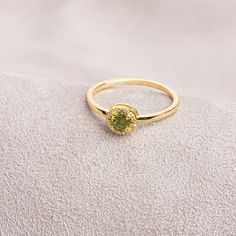 "Peridot: This stone, called the \"Emerald of the Night\" in ancient Egypt, is believed to protect the person using it like a shield. Our round cut ring with peridot stones surrounded by real diamonds is produced to always be with you. It can be given as a gift to yourself, your friends, your lover or your mother. Crown your happy days with our ring. We hope you create beautiful memories with our ring.   Peridot is the birthstone for those born in August. Don't forget to visit our store for all Green Halo Promise Ring, Yellow Gold Rings With Halo And Round Stone, 14k Gold Halo Jewelry For May Birthstone, Gold Halo Ring With Gemstone In 14k Gold, Green 14k Gold Promise Birthstone Ring, Yellow Gold Peridot Jewelry With Halo Setting, Green Halo Rings For Gift, Green Halo Rings As A Gift, 14k Gold Green Diamond Ring With Gemstone