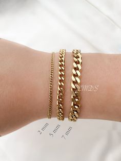 *Free TRACKABLE shipping within Canada and US.  Our waterproof Curb Chain Bracelet is available in 3 widths: 2mm for subtle elegance, 5mm for a classic statement, and 7mm for bold confidence. Choose from 18k gold PVD plated or silver finish for. The 5 to 8 inch length options, with a 2.25-inch extender, ensures a comfortable fit for various wrist sizes.  Add a letter charm for a personalized touch. Pair it with our matching necklace here: https://www.etsy.com/ca/listing/1330725387/curb-chain-nec Chunky Gold Bracelet, Curb Chain Bracelet, Gold Armband, Bracelet Dainty, Purple Ribbon, Jewelry Card, Letter Charms, Initial Charm, Matching Necklaces