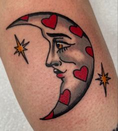 a close up of a person's tattoo with a crescent moon and hearts on it