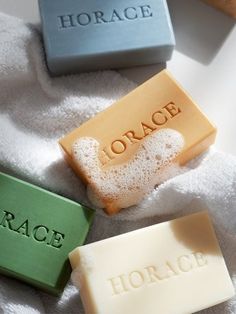 three soap bars sitting on top of a white towel next to each other with the word grace written on them