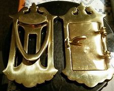 two gold buckles sitting on top of a table