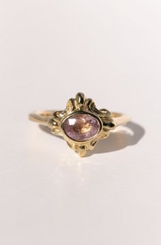 The Sainte ring is the "objet d’art" of the Paris collection - a term attributed to objects of artistic worth, detail, and beauty. This hand carved 18k gold ring has layers of details, with flourishes radiating from the center and wrapping around to the back. In the center is a .87ct mauve pink sapphire. Look closely into this one-of-a-kind gem and you'll see streaking inclusions that catch the light and shimmer in an incredibly unique way. The face of the ring spans 12mm x 14mm. Ready to ship a Elegant Ceremonial Rings With Gemstone, Elegant Ceremonial Gemstone Rings, Fine Jewelry Gold Ruby Ring With Intricate Design, Gold Ruby Ring With Intricate Design, Unique Oval Engraved Ring With Gemstone, Unique Engraved Oval Ring With Gemstone, Heirloom Ceremonial Gemstone Rings, Heirloom Carved Yellow Gold Rings, Ceremonial 14k Gold Jewelry With Rose Cut Diamonds