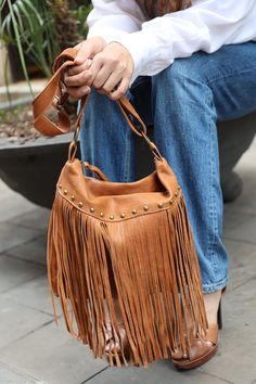 "Iconic and elegant fringe crossbody bag handmade in our atelier with camel color leather. This soft leather hobo bag has a boho style reinforced by the long fringes on the front, which measure 30 cm. long (11,8\") and creates beautiful movements when you walk. With an adjustable handle that is 3 centimeters wide. The length is adjustable between 60-120 cm. (23,6 to 47,2\") for wearing the nag on the shoulder or crossbody. A medium sized purse perfect for carrying your everyday stuff: wallet, ke Bohemian Light Brown Tote Shoulder Bag, Brown Bucket Bag With Tassels For Everyday, Bohemian Shoulder Bag With Tassels For Fall, Bohemian Brown Bucket Bag With Tassels, Fall Fringe Hobo Shoulder Bag, Brown Fringe Shoulder Bag For Daily Use, Travel Bucket Bag With Tassels In Brown, Brown Tassel Bucket Bag For Daily Use, Bohemian Leather Hobo Bag For Fall