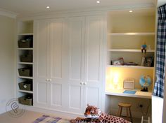 a bedroom with a bed, desk and bookcases on the wall next to it