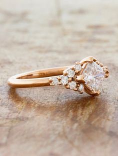 a close up of a diamond ring on a wooden surface