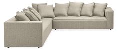 a large sectional couch with pillows on the top and bottom corner, in light grey fabric