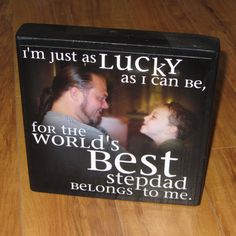 a black box with a picture of a man and woman on it that says, i'm just as lucky as i can be for the world's best stepdad belongs to me