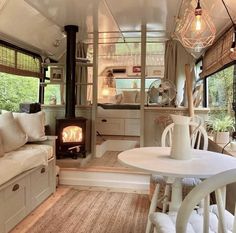 a living area with a couch, table and stove in the corner next to windows