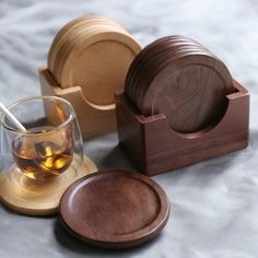 three wooden coasters and two glasses on a table