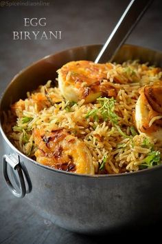 a pan filled with rice and shrimp on top of a table