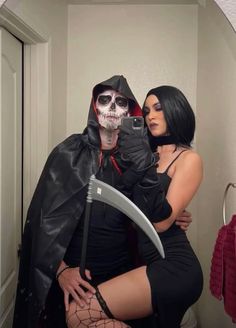 a woman dressed as a skeleton hugging a man with a knife in her hand while he is taking a selfie