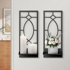 two black metal wall shelves with candles and flowers