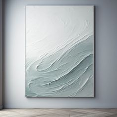 an abstract painting hangs on the wall in a room with hardwood floors and white walls