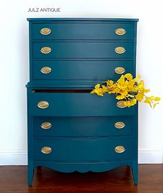 a blue dresser with yellow flowers on top