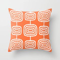 an orange and white decorative pillow with square shapes on the front, in various sizes