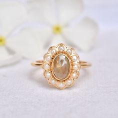 "A cozy fresh water pearl halo around a 1.27 carat chocolate brown rough diamond, bezel set in solid 14k gold - this ring is a hot chocolate on a cold day! A perfect alternative bridal ring, this unique ring also makes for a stunning long distance winter holiday gift! * Gold : 14k Solid Yellow Gold * Gold Wt. : ~3.5gms * Gemstone 1 (Centre) : Natural Diamond * Diamond Color : Light Muddy Brown * Diamond Weight : 0.76 Ct * Gemstone 2 (Halo) : Fresh Water Pearls * Weight : 0.66 Ct * Authenticity C Heirloom 14k Gold Pearl Ring With Rose Cut Diamonds, Oval Yellow Gold Pearl Ring With Halo Setting, Heirloom Pearl Ring With Rose Cut Diamonds For Gift, Heirloom Oval Pearl Ring With Rose Cut Diamonds, Heirloom Pearl Ring With Rose Cut Diamonds, Oval Pearl Ring With Rose Cut Diamonds, Heirloom Style Pearl Ring With Rose Cut Diamonds, Oval Pearl Ring With Rose Cut Diamonds For Wedding, Wdding Ring