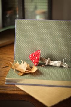 a close up of a card on a table with a leaf laying on top of it