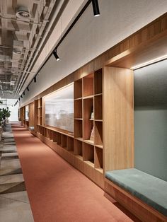 an empty room with wooden shelves and carpeted flooring on the walls, along with potted plants