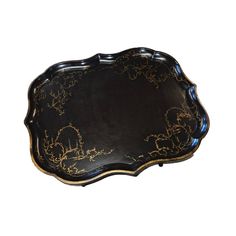 an ornate black and gold tray on a white background