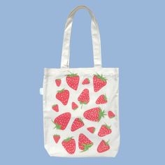 This bright red strawberry tote bag will add a pop of colour and liveliness to your wardrobe! Pair our strawberry tote bag with a cute little picnic outfit and you will be looking ‘berry’ sweet! All of our designs are double-sided so that you have the option to wear a more simple look, or a more bold look! Our tote bags also have an inner pocket! It is the perfect size to hold your phone, wallet, chapstick, and any little trinkets so you don’t have to dig around the bottom of your tote bag! Features: Inner pocket Fits laptop Spacious compartment Double-sided design Designed in Australia Artwork by Mel Instagram: melbdesign_ Material: 100% Cotton Calico Approximate Dimensions: Length: 40cm, Width: 34cm Handle length: 35cm Pocket: 17cm x 17cm Care instructions: Hand wash with cold water and Trendy Red Canvas Gift Bag, Cute Red Bags For Everyday Use, Trendy Red Canvas Bag For Summer, Cute Strawberry Print Bags For Everyday Use, Red Bag With Strawberry Print As Gift, Cute Red Bags For Spring, Casual Rectangular Bag With Strawberry Print, Cute Summer Cotton Shoulder Bag, Cute Cotton Shoulder Bag For Summer