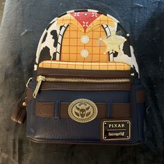 This Disney Loungefly Toy Story Woody Western Vegan Leather Mini Backpack Is A Must-Have For Any Fan Of The Franchise. With Its Stylish Design And Functional Size, It's Perfect For Carrying All Your Essentials On The Go. The Backpack Features Woody, The Beloved Character From The Movie, And Is Made From High-Quality Vegan Leather For A Durable And Long-Lasting Design. The Backpack Is Perfect For Collectors And Fans Of All Ages, With Its Contemporary Style And Feel. The Multicolor Design Adds A P Disney Leather Backpack For Disney Trips, Disney Leather School Bags, Disney Leather School Backpack, Disney Leather Backpack For School, Disney Everyday Brown Bags, Brown Disney Bags For Everyday Use, Disney Leather Backpack, Disney Style Brown Bag For Everyday Use, Disney Leather Backpack For Everyday Use