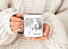 a woman holding a coffee mug with an image of winnie the pooh on it