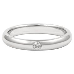 a white gold wedding band with a single diamond