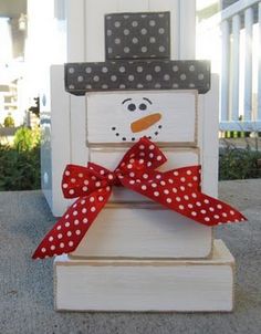 a snowman sitting on top of a white chair with polka dot ribbon around it