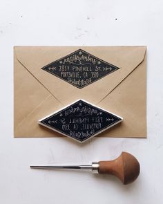 an envelope with writing on it and a paintbrush next to it, which is being used as a stamp