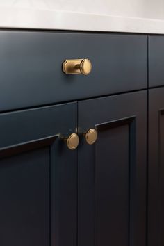 an image of a kitchen cabinet with brass knobs