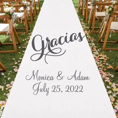 a wedding aisle with chairs and flowers on the grass in front of it is decorated with love