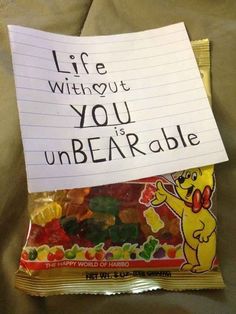 a bag of gummy bears sitting on top of a bed next to a note that says life without you unbearable