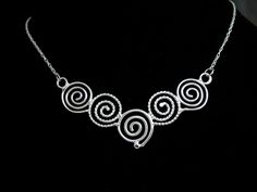 I like spirals and in Celtic lore, they can represent going from stages of oneself primal points to enlightenment, and though most of us have a way to go, we can at least adorn one in hopes of always continuing on a path of growth and self-reflection. This Celtic Spiral Necklace, in sterling silver, with each scroll hand-made in alternating plain and twist 16 gauge wire, embodies Celtic symbolism. I wanted to fabricate something meaningful and magical within the spirit of these ancient symbols. Silver Spiral Bohemian Necklace, Bohemian Silver Spiral Necklace, Spiral Wire Wrapped Sterling Silver Necklace, Adjustable Spiral Necklace Nickel Free, Adjustable Spiral Nickel-free Necklace, Unique Spiral Sterling Silver Necklace, Handmade Spiral Silver Necklace, Handmade Silver Spiral Necklace, Unique Hand Forged Spiral Jewelry