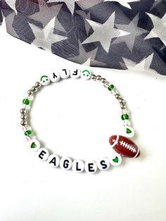 Show your unwavering support for the Philadelphia Eagles with our exquisite beaded bracelet. Each bead is a tribute to the team's legacy, adorned in the iconic green and silver hues that echo the passion of Eagles Nation. This meticulously crafted bracelet captures the thrill of the game, allowing you to carry the energy of victory wherever you go. Whether you're cheering from the stands or expressing your devotion on any occasion, the Philadelphia Eagles Beaded Bracelet is a symbol of pride, unity, and the unbreakable bond between you and your favorite team. Stretch bracelet for comfort. Philadelphia Eagles Perler Bead Patterns, Philadelphia Eagles Cross Stitch, Eagles Bracelet, Adjustable Bracelets For Game Day, Football Season, Football Bracelet, Philadelphia Eagles, Eagles, Philadelphia, Stretch Bracelets