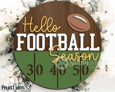 a wooden sign that says hello football season with a football on it and flowers in the background