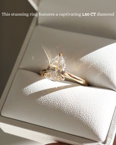 a woman's hand holding an engagement ring in a white box with the words, this stunning features a captivating lqct diamond