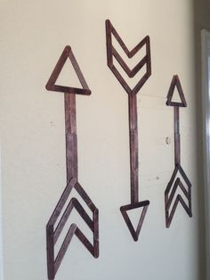 three metal arrows are hanging on the wall