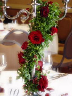 the table is set with red roses and silver candelabra