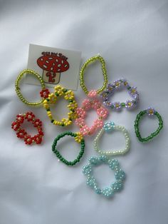 several bracelets are arranged on top of a white sheet with a card in the middle