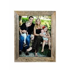 a family with two children and one dog posing for a photo in a wooden frame