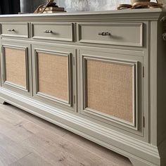 an old dresser is painted gray with wicker doors