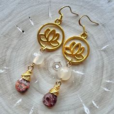 These earrings are comprised of gold plated lotus charms, Agate beads and gold wire-wrapped Leopardskin Jasper teardrops. They are 2.875'' in length including their gold plated ear wires and have a 2.5'' drop. At only 0.4 ounces, they are very lightweight and perfect for extended wear! Nickel and Lead Free.  ------------------------------ All of my jewelry pieces come in a stylish drawstring pouch, ready to wear or gift! Items will ship within 1-3 business days after an order is placed and are always packed with care & love in a pet-friendly home.  **Note** Jewelry items are not waterproof, therefore it is suggested to remove prior to bathing, swimming, etc. -------------------------------- Thanks for viewing this item!  Please contact me with any questions!  I do custom orders! ~Rachel~ T Gold Agate Teardrop Earrings, Gold Teardrop Agate Earrings, Gold Teardrop Agate Jewelry, Gold Teardrop Earrings With Gemstone Beads, Gold Agate Earrings For Jewelry Making, Handmade Gold Agate Earrings, Gold Agate Earrings With Natural Stones, Gold Spiritual Earrings With Gemstone Beads, Gold Dangle Earrings With Gemstone Beads