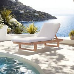 a white chaise lounge chair sitting next to a swimming pool